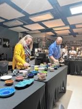 EB1 Wallkill Valley Regional High School staff members Lauren Donohue and William Panfile choose a handmade bowl at the ‘Empty Bowls’ fundraiser. (Photos provided)