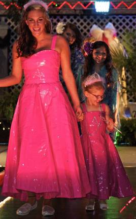 Ashley Prior, left, and her niece Adriana Hoppe, model two duct tape gowns with rhinestones interlaced with their initials. Ashley designed both. In the background, left, Rebecca Johnson, student designer and model Brooke Munoz. Photos by Joe Hicks