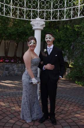 Behind the masks are prom goers Daria Ferdine and Matthew Corsello.