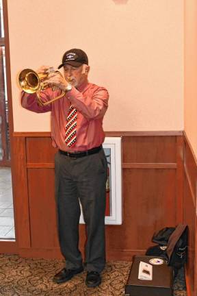 Air Force veteran Robert Caggiano plays taps during the ceremony.