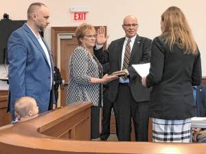 Former Lafayette Mayor Alan Henderson takes the oath of office as a member of the Sussex County Board of County Commissioners on Wednesday, Jan. 1. From left are his son, Andrew; his wife, Lorie; and his daughter, Vanessa Henderson-Aikens, who administered the oath. (Photo by Kathy Shwiff)