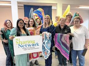 Participants in Hangin’ By A Thread’s Wrapped in Love event show off some of their handmade shawls and lap blankets. (Photo courtesy of NJ Sharing Network)