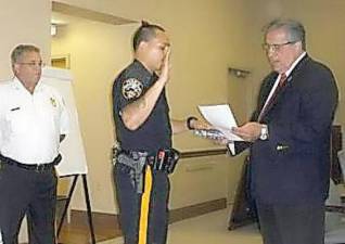 Then-Mayor Vic Marotta swears in Patrolman Emanuel Rivera at an August 2013 township council meeting as Chief Roy Wherry looks on. (File photo by Mike Zummo)