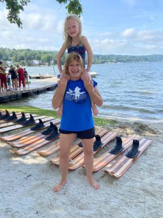 Marjy Murphy, 66, holds Marina Lieb, 6, on her shoulders during a practice of the Lake Mohawk Ski Hawks. Murphy is the oldest member of the water-ski team.