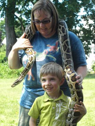 Dawn Masino with Rizzo's Reptile Discovery lets Zachary Zampella, 5, of Ogdensburg pet the Burmese python.
