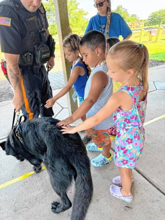 Children pet Ace, a German Shepherd who works with Detective Michael Scott in the Sussex County Sheriff’s Office Canine Unit.