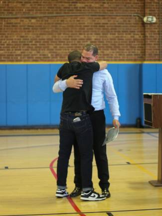 A son hugs his father before he becomes naturalized in Newburgh. Photo: Brianna Kimmel.