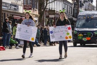 From left, sisters Magdalen and Olivia Costello march in the St. Patrick’s Day Parade on March 18 in Newton to highlight the Weekend Bag Program to fight hunger. (Photo by John Hester)