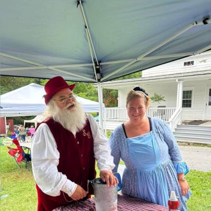 John Bradford cranks the old-fashioned ice cream maker. At right is Ashley Ziccardi, curator of the Rev. Elias Van Bunschooten Museum.