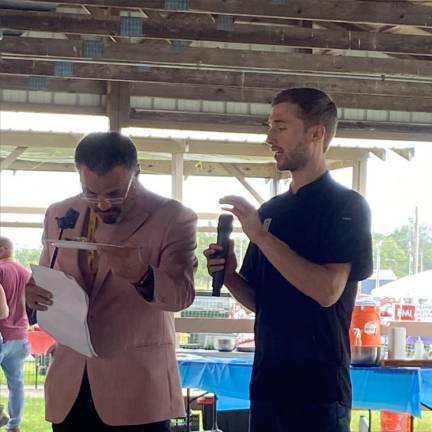 Orlando Rodriguez, MC of the competition, looks at the food. Chef Jake Verwys, right, won the cooking contest.