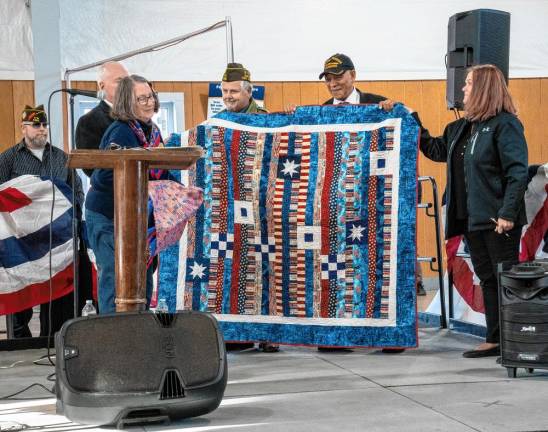 <b>VP4 Carol Johnson presents a Quilt of Valor to keynote speaker Emerson Crooks, second from right, and Frank Toth, center, who received a certificate of appreciation.</b>