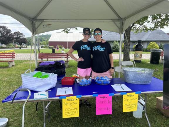 Melissa and Nicole Soucy sell T-shirts and help people sign up for the costume contest and peanut butter eating contest.