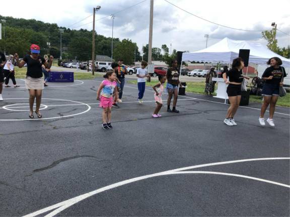 Members of the crowd jump at the DJ’s instruction at the Juneteenth celebration