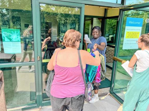 Volunteer Gwen Yaskovic distributes new backpacks filled with school supplies to a local family. (Photo provided)