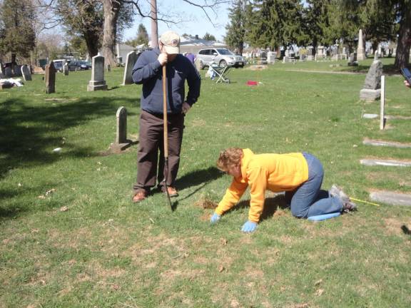 DAR member Wendy Wyman begins to dig after Richard Ziccardi has tested the earth and found a covered marker in the area.