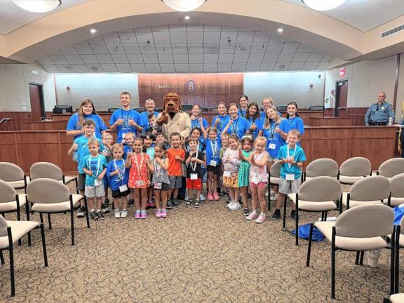 Participants and teen volunteers with the Safety Program pose with McGruff the Crime Dog.