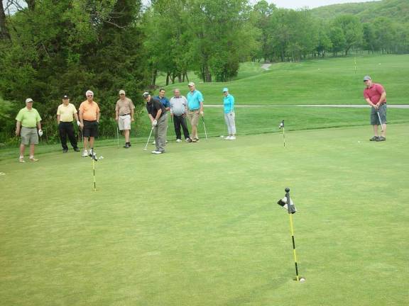 Photo courtesy John T. Whiting Putting Contest golfer sinks the first ace of the competition