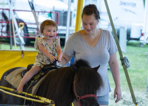 FR20 Grace Ross, 2, of Vernon holds on to the saddle as her mother, Ashley Mayers, walks alongside. (Photo by John Hester)