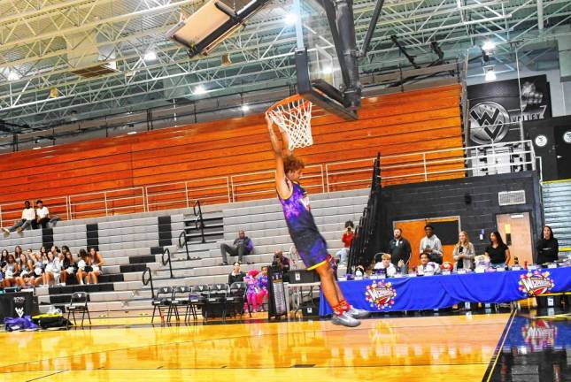 A Harlem Wizard swings from the hoop.