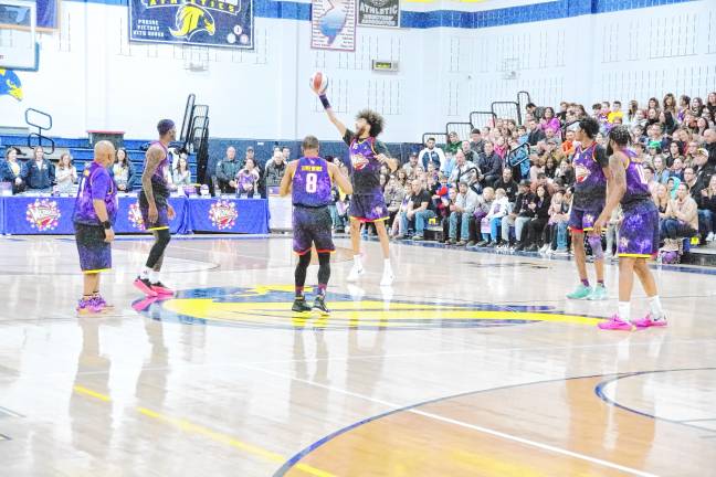 The Harlem Wizards doing fancy ball handling at the center of the court.