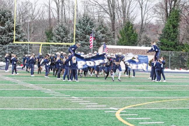 The Pope John Lions break through a banner held by cheerleaders as they enter the field for the game.