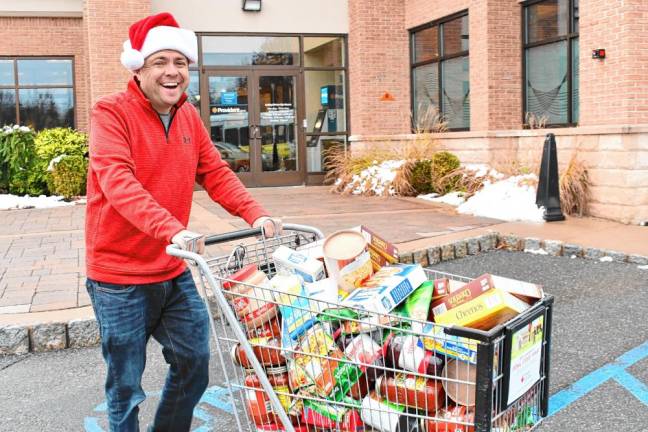 <b>Steve Allan of radio station 102.3 WSUS brings donated food to a Sussex County Skylands Ride bus Friday, Nov. 22 at the Provident Bank in Sparta. (Photo by Maria Kovic)</b>