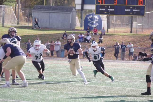 Pope John quarterback Christopher Dietrich is pursued by St. Joseph defenders. (Photo by George Leroy Hunter)