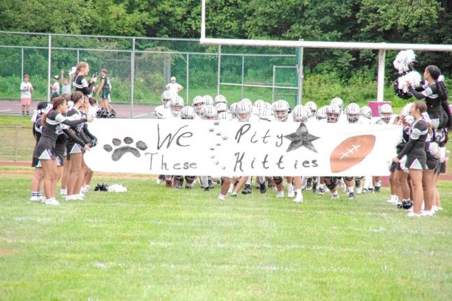 <b>Before the start of the game, the Wallkill Valley Rangers are about to break through a sign held by the cheerleaders. The word ‘kitties’ refers to the High Point Wildcats.</b>