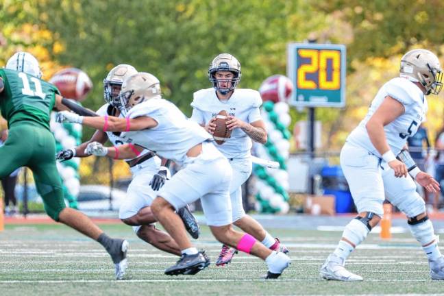 <b>Pope John quarterback Luke Irwin looks downfield as his offensive line provides protection from the Delbarton defenders. </b>