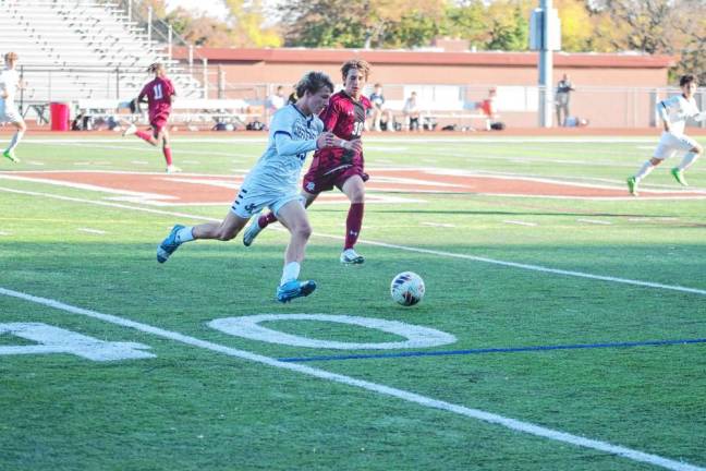 A Jefferson Falcon and a Newton Brave pursue the soccer ball.