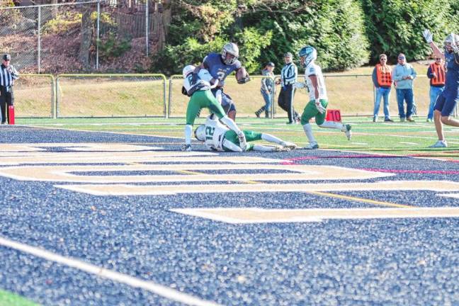 <b>SP1 In the second half of the game against Camden Catholic on Saturday, Nov. 9, Pope John ball carrier Tylik Hill makes it to the end zone, dragging defenders with him for a touchdown. The Lions won, 42-7. (Photo by George Leroy Hunter)</b>