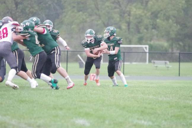 Sussex Tech quarterback Brian Gruber hands the ball off to running back Andrew Baker (22) during the first half. Baker gained 156 yards on the ground and scored two touchdowns.