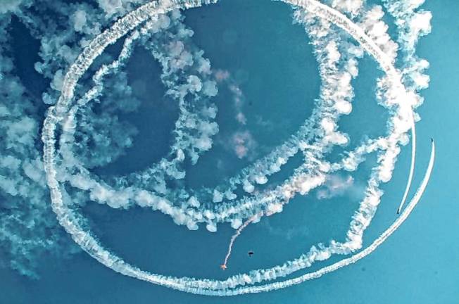 AIR3 Rob Holland, one of the airshow pilots, performs ‘Circle the Jumpers’ where he circles the skydivers with smoke as they jump. (Photo by Ed Bailey)