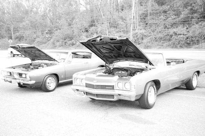 A 1967 Plymouth Barracuda alongside a 1972 Chevrolet Impala Convertible.