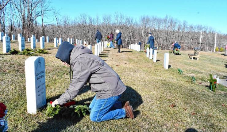 A volunteer places a wreath on a grave Saturday, Dec. 14 at the Northern New Jersey Veterans Memorial Cemetery in Sparta. (Photo by Maria Kovic)