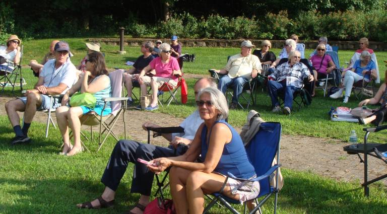 Concert goers enjoy the music on a lovely summer evening.