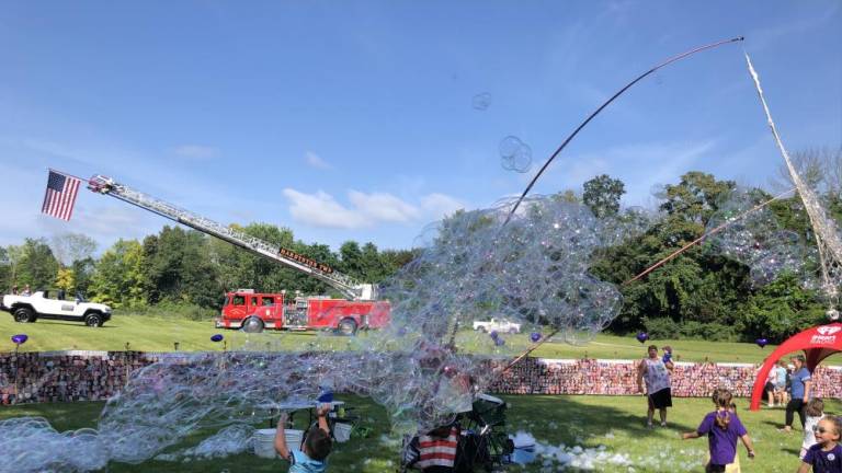 Children play with bubbles before the start of the walk.